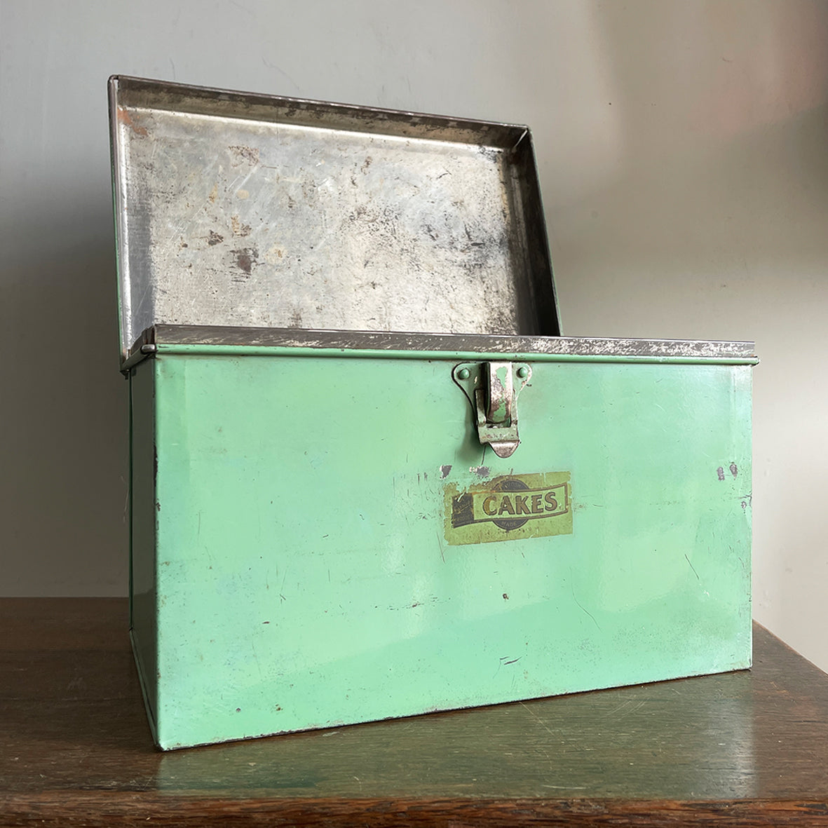 A Vintage Garrison Cake Tin in a fab duck egg green, and still having its 'CAKES' water slide sticker to the front. Open up the latch and find an inner tray that lifts out to reveal a larger space beneath - SHOP NOW - www.intovintage.co.uk