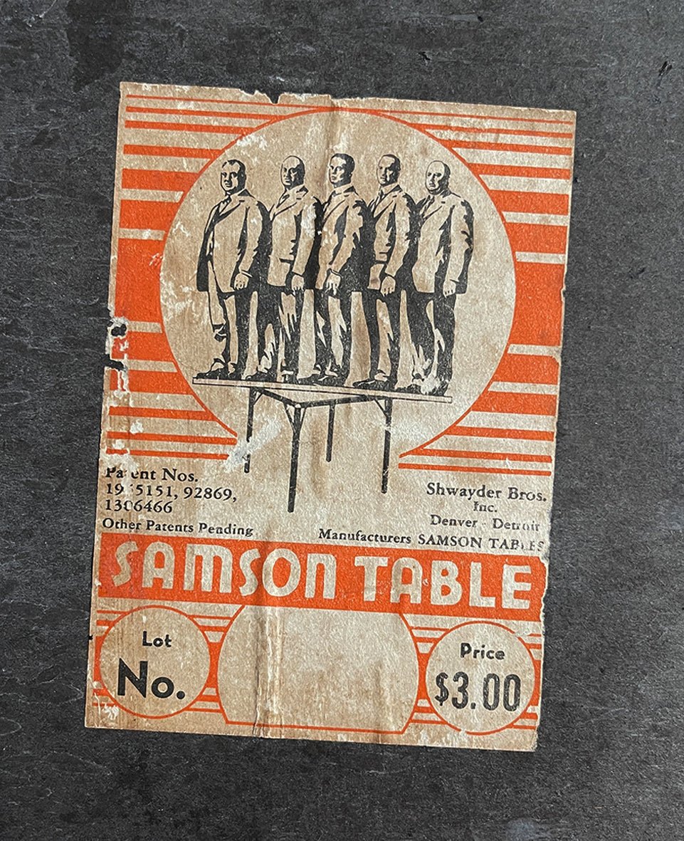 A Samson Folding Chess Table by Schwayder Brothers of Detroit. With a studded edge, metal corners and sturdy folding legs. It has a great aged look to it with original sales sticker underneath showing five gents standing on the table to showcase its strength, hence the name 'Samson'! SHOP NOW - www.intovintage.co.uk