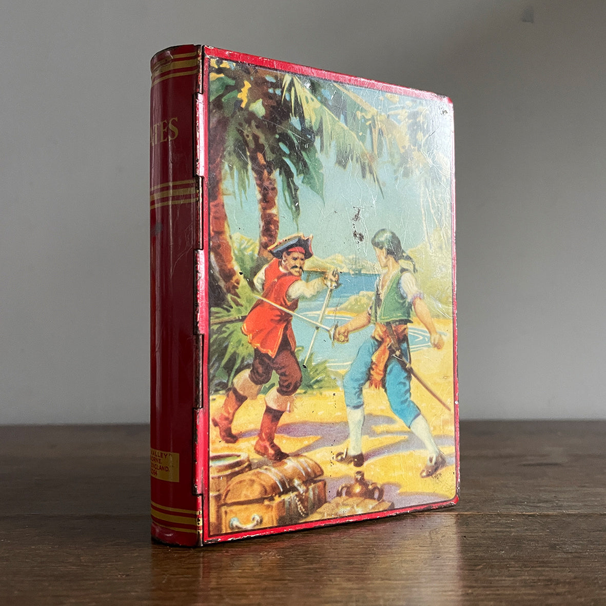 A Vintage 1950s Chad Valley Pirate Tin-Plate Money Box that looks like a book. With a cracking pirate image to the front and the word 'PIRATES' on the spine - SHOP NOW - www.intoVintage.co.uk