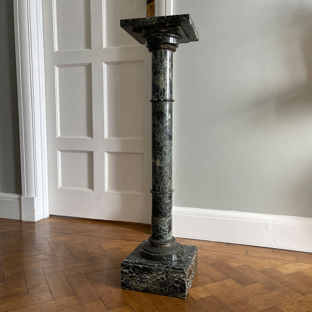 An impressive guilt-bronze mounted pedestal, hand-carved from a deep green veined marble. The substantial stepped square marble base, gives the plinth excellent stability and is topped by an ornate gilt-bronze capital. The column rises upwards terminating in an empire gilt-bronze collar. A square top is fitted with a mounted peg, this slots into an inset brass fitting in the top of a smaller square of marble which sits atop the column - SHOP NOW - www.intovintage.co.uk