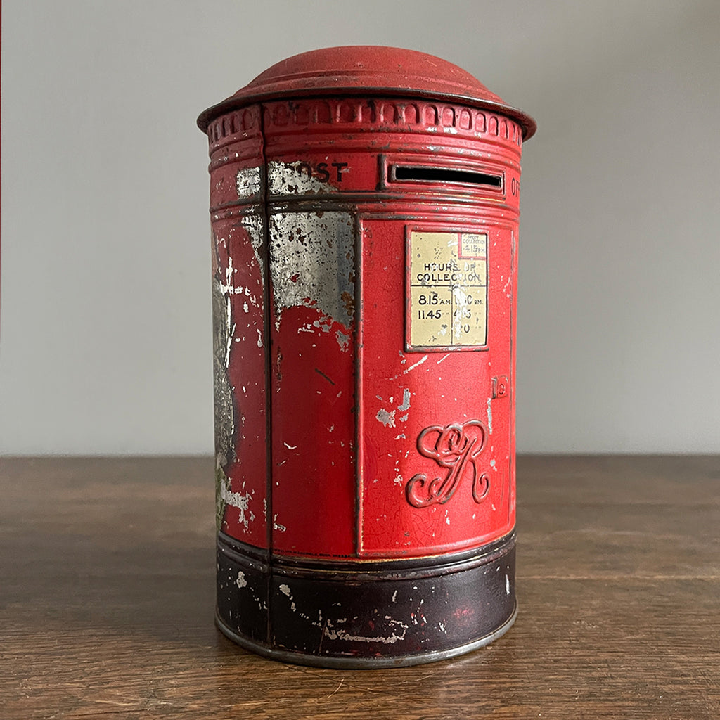 An charming early 20th Century Post Box Tin with lid. It has a slot for your pennies and a handy alphabet on the reverse edged with coins and stamps - SHOP NOW - www.intovintage.co.uk