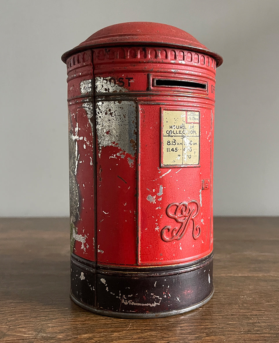 An charming early 20th Century Post Box Tin with lid. It has a slot for your pennies and a handy alphabet on the reverse edged with coins and stamps - SHOP NOW - www.intovintage.co.uk