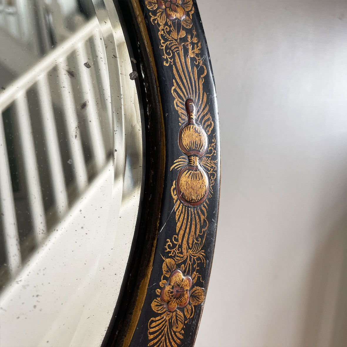 An Antique quality decorated black lacquer oval wall mirror. The original mirrored glass is beveled, has good foxing and is in good condition - SHOP NOW - www.intovintage.co.uk