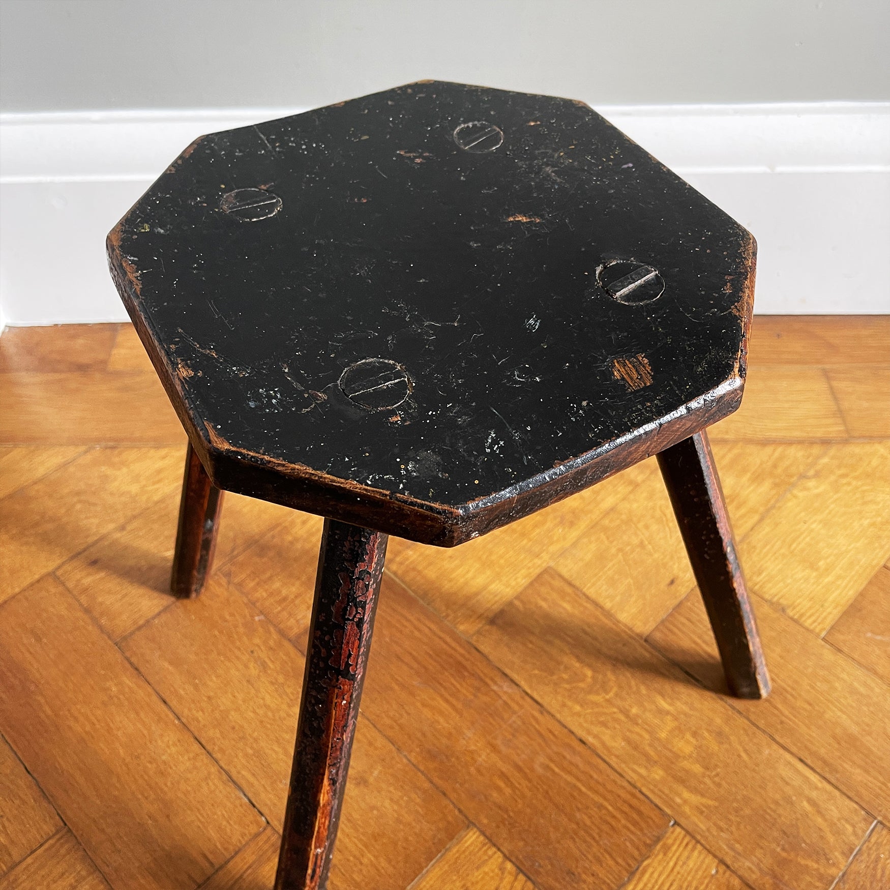 An Antique Elm Milking Stool with a wonder original black painted finish that has worn away over its years of use to provide the perfect finish. Very solid and sitting on four tapered straight edged legs -SHOP NOW - www.intovintage.co.uk