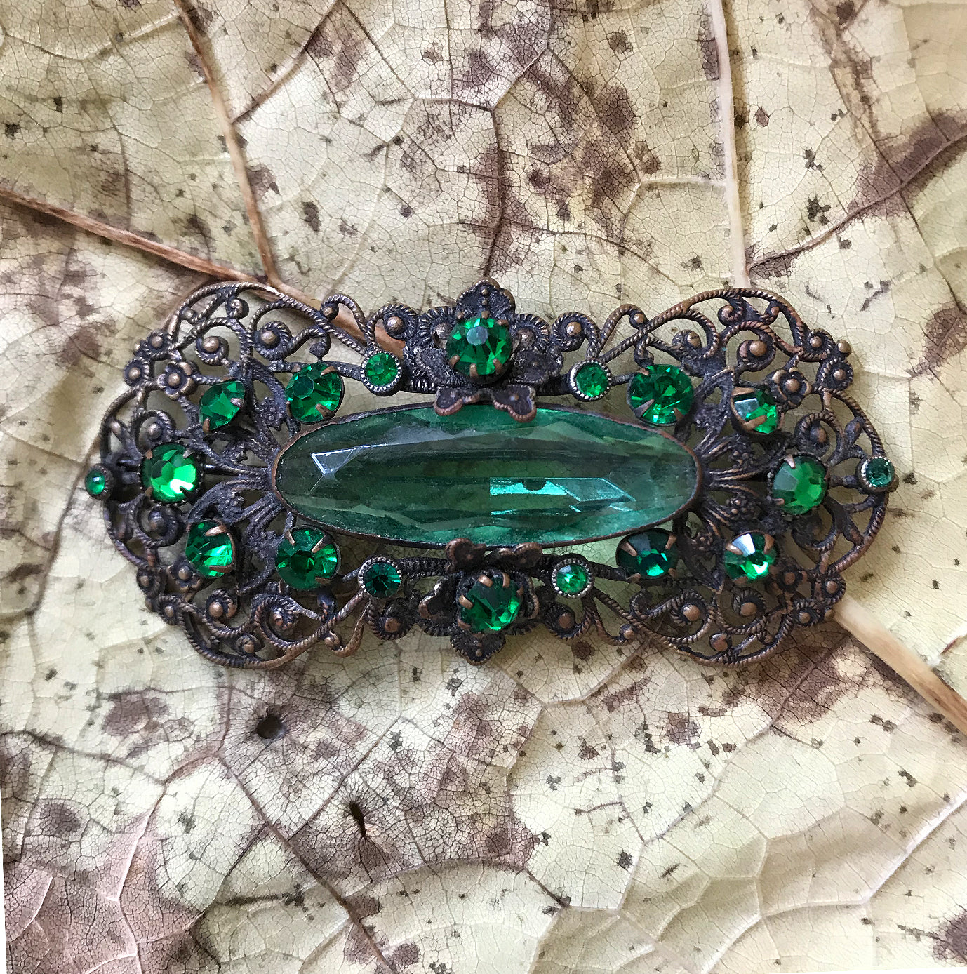 Excellent quality Edwardian Brooch with intricate design detail. Numerous faceted glass emeralds surrounding one larger green glass gem. - SHOP NOW -  www.intovintage.co.uk